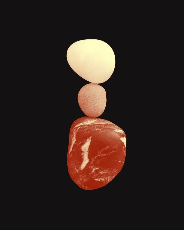 Three balanced stones stacked on a black background